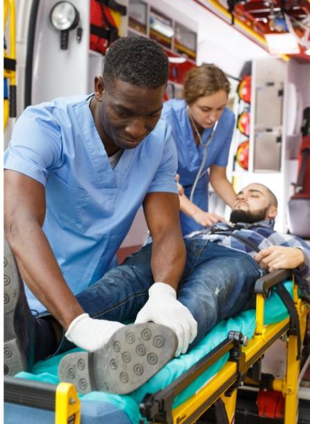 two healthcare employees working on patient exiting ambulence